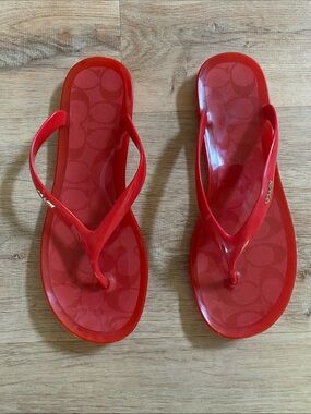 Coach coral-red flip-flops with gold-toned hardware